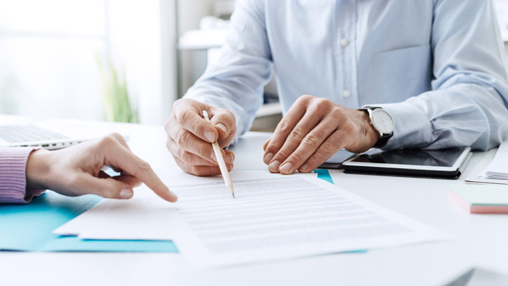 Personnes autour d'un bureau relisant un document