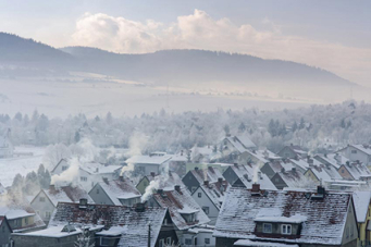 Village enneigé avec fumés sortant des cheminés 