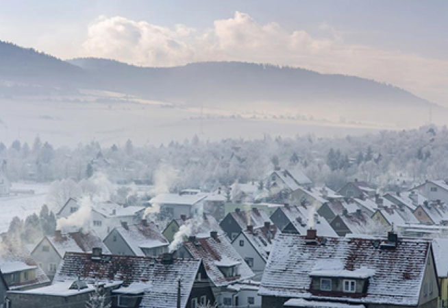 Village enneigé avec fumés sortant des cheminés 